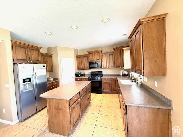 1093 S 1960 E, Spanish Fork, UT 84660 - kitchen featuring black appliances, a kitchen island, a sink, light tile patterned flooring, and brown cabinets