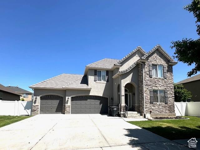 1093 S 1960 E, Spanish Fork, UT 84660 - view of front of home with an attached garage, stucco siding, driveway, stone siding, and a tiled roof