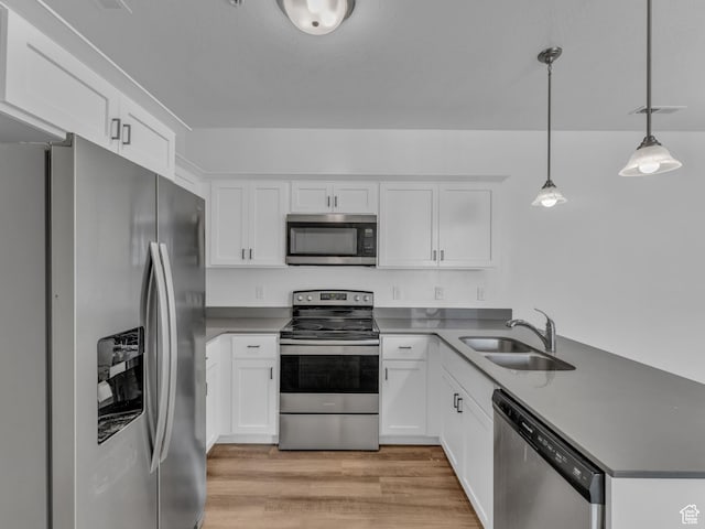 14569 S Bloom Dr W Unit L204, Herriman, UT 84096 - kitchen with appliances with stainless steel finishes, a sink, a peninsula, light wood-style floors, and white cabinetry