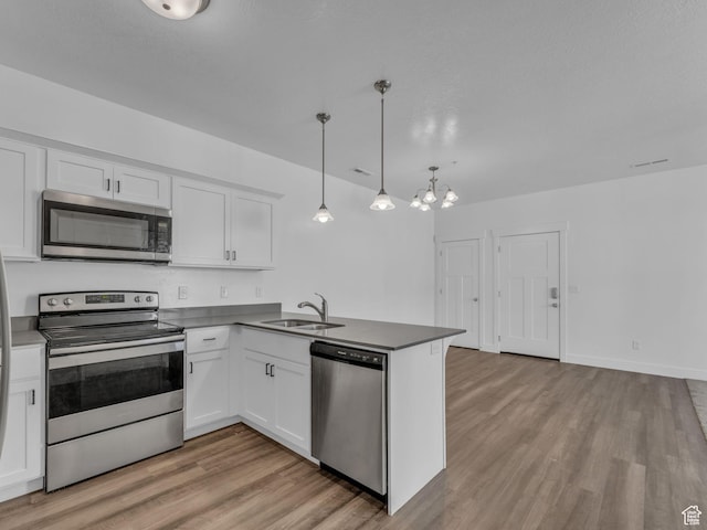 14569 S Bloom Dr W Unit L204, Herriman, UT 84096 - kitchen featuring stainless steel appliances, a sink, light wood-style flooring, white cabinets, and a peninsula