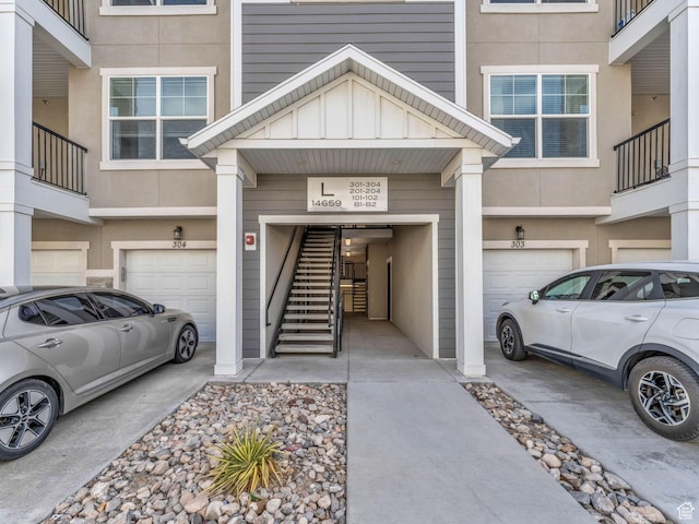 14569 S Bloom Dr W Unit L204, Herriman, UT 84096 - view of exterior entry with an attached garage, driveway, and stucco siding