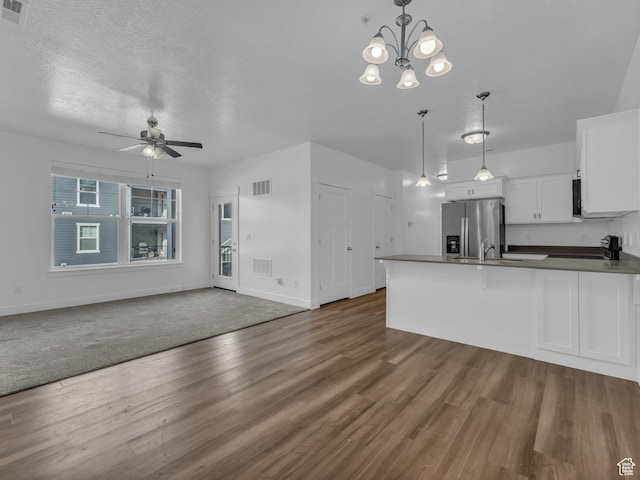 14569 S Bloom Dr W Unit L204, Herriman, UT 84096 - kitchen featuring ceiling fan, dark countertops, a peninsula, white cabinets, and open floor plan