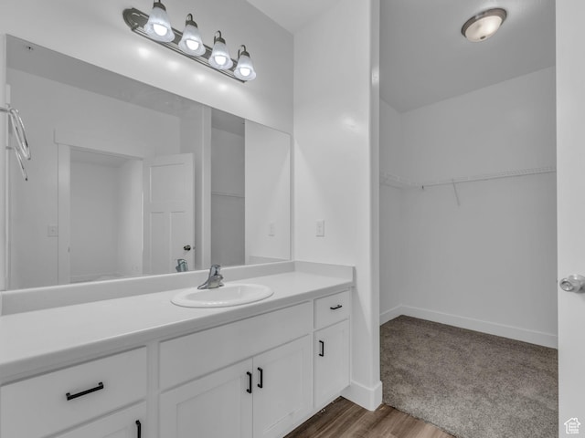 14569 S Bloom Dr W Unit L204, Herriman, UT 84096 - bathroom featuring vanity, a spacious closet, baseboards, and wood finished floors