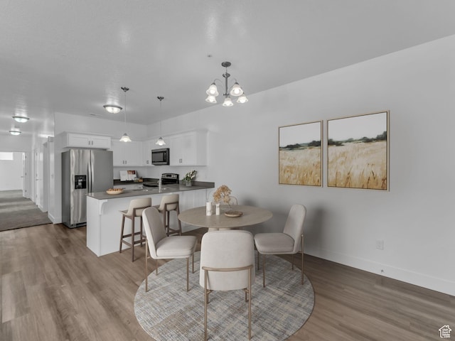 14569 S Bloom Dr W Unit L204, Herriman, UT 84096 - dining area featuring wood finished floors, baseboards, and a chandelier