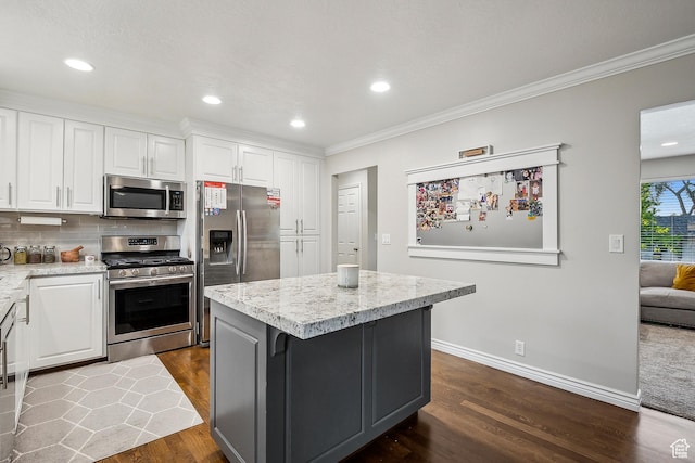 946 E 10715 S, Sandy, UT 84094 - kitchen featuring appliances with stainless steel finishes, crown molding, white cabinetry, dark wood-style floors, and a center island