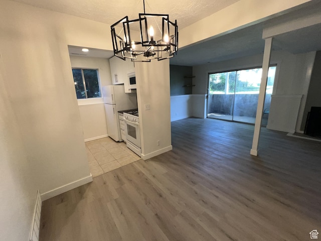 17 E 400 N Unit 27C, Bountiful, UT 84010 - unfurnished dining area with a chandelier, light wood finished floors, and baseboards