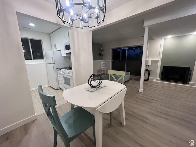 17 E 400 N Unit 27C, Bountiful, UT 84010 - dining room with a chandelier, light wood-style flooring, and a fireplace