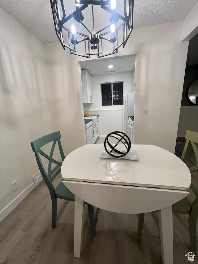 17 E 400 N Unit 27C, Bountiful, UT 84010 - dining area featuring light wood finished floors, a textured ceiling, and a chandelier