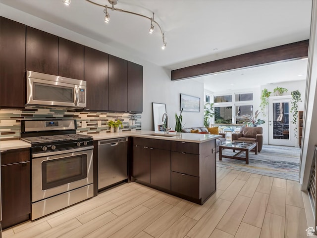 7701 S Navarro View Ct, Midvale, UT 84047 - kitchen with stainless steel appliances, a peninsula, a sink, light countertops, and beamed ceiling