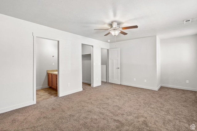 14394 S Oakfield Way, Herriman, UT 84096 - unfurnished bedroom featuring light carpet, ensuite bathroom, a spacious closet, baseboards, and a ceiling fan