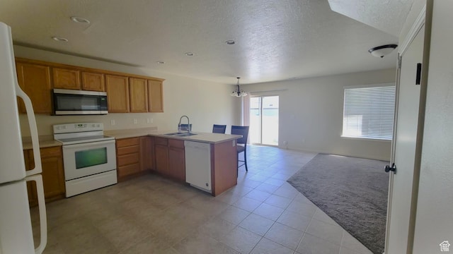 581 S 910 W Unit 86, Pleasant Grove, UT 84062 - kitchen featuring white appliances, a peninsula, a sink, a textured ceiling, and open floor plan