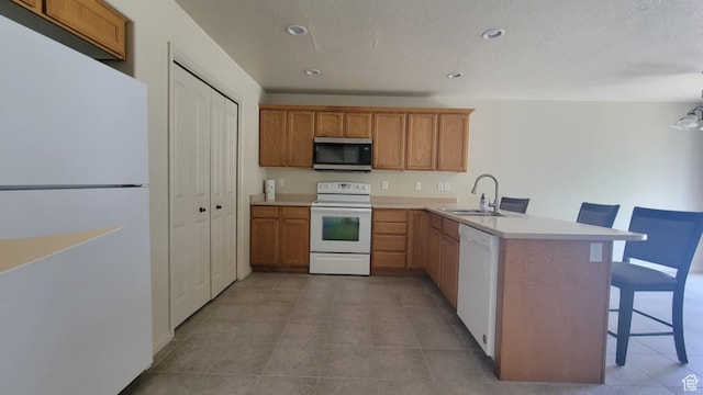 581 S 910 W Unit 86, Pleasant Grove, UT 84062 - kitchen featuring white appliances, a sink, a breakfast bar area, a peninsula, and light countertops