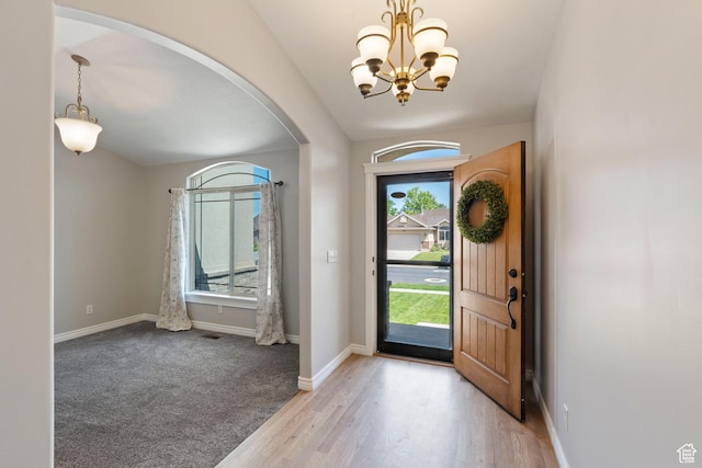 2167 W 2200 S, Syracuse, UT 84075 - entrance foyer featuring arched walkways, a chandelier, baseboards, and light wood-style flooring