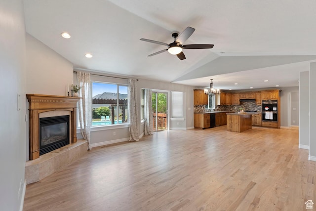 2167 W 2200 S, Syracuse, UT 84075 - unfurnished living room featuring a fireplace, a chandelier, light wood-style floors, lofted ceiling, and a ceiling fan