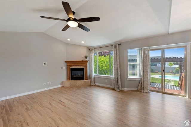 2167 W 2200 S, Syracuse, UT 84075 - unfurnished living room with baseboards, ceiling fan, wood finished floors, a glass covered fireplace, and lofted ceiling