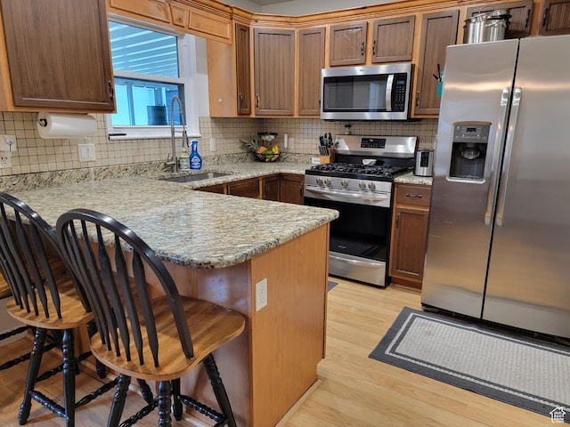 264 W 550 N, Santaquin, UT 84655 - kitchen with appliances with stainless steel finishes, a sink, a peninsula, light wood-type flooring, and a breakfast bar area