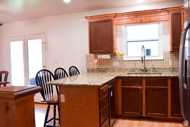 264 W 550 N, Santaquin, UT 84655 - kitchen featuring a sink, a breakfast bar, light wood-type flooring, a peninsula, and backsplash