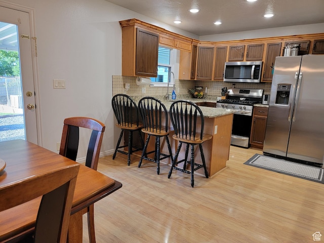 264 W 550 N, Santaquin, UT 84655 - kitchen with stainless steel appliances, a peninsula, light wood-style floors, decorative backsplash, and recessed lighting