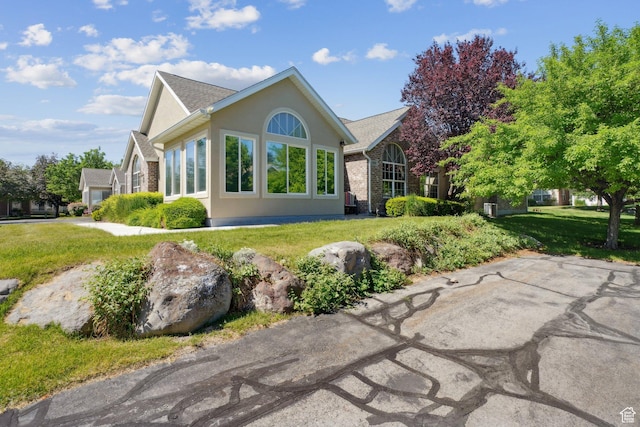 2082 W Jordan Villa Dr, West Jordan, UT 84088 - back of house with a lawn and stucco siding