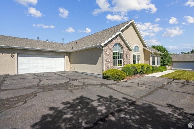 2082 W Jordan Villa Dr, West Jordan, UT 84088 - view of side of property with asphalt driveway, stucco siding, and a garage