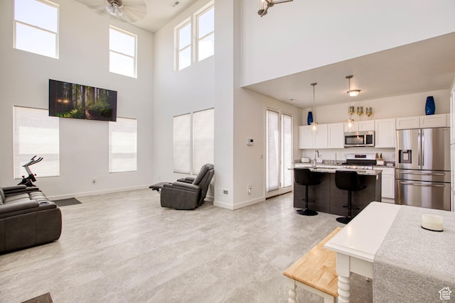 7776 S Iron Core Ln, West Jordan, UT 84081 - living room with baseboards, a towering ceiling, and ceiling fan