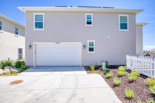 7776 S Iron Core Ln, West Jordan, UT 84081 - view of side of home featuring stucco siding, concrete driveway, and an attached garage