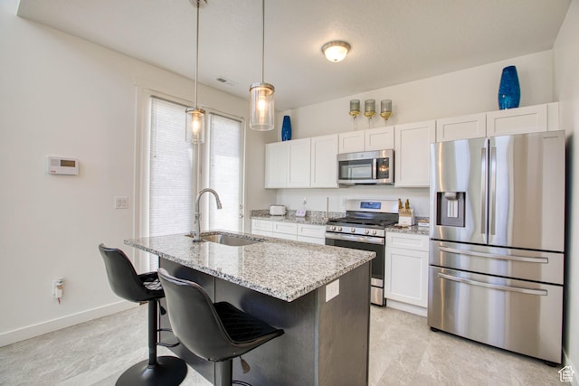 7776 S Iron Core Ln, West Jordan, UT 84081 - kitchen featuring stainless steel appliances, a sink, white cabinets, and a center island with sink