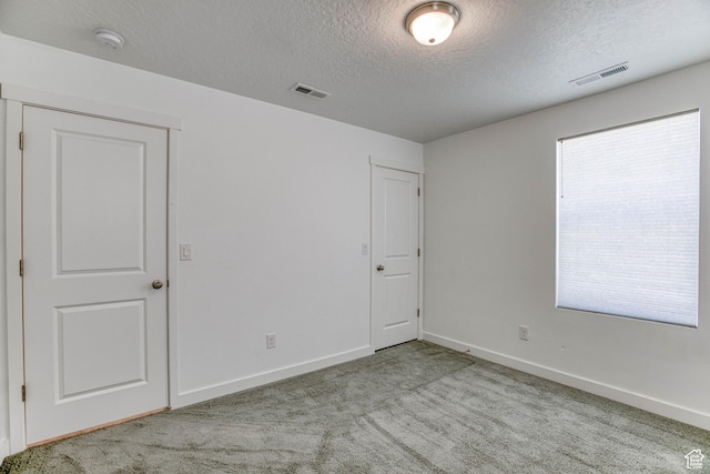 7776 S Iron Core Ln, West Jordan, UT 84081 - unfurnished bedroom featuring a textured ceiling, light carpet, and baseboards