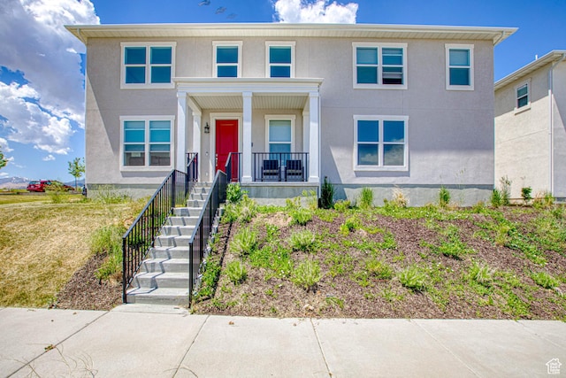 7776 S Iron Core Ln, West Jordan, UT 84081 - view of front of property featuring covered porch, stucco siding, and stairway