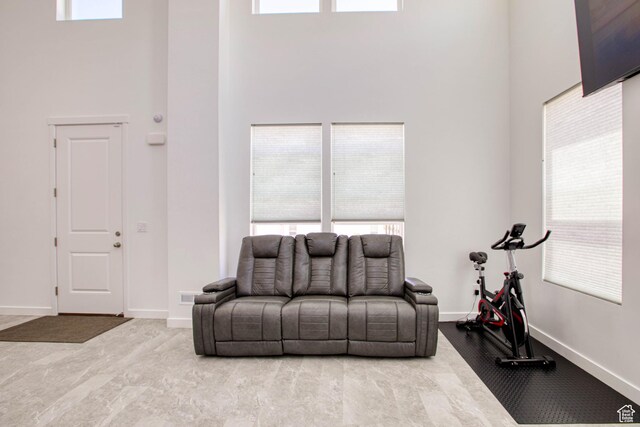 7776 S Iron Core Ln, West Jordan, UT 84081 - living room featuring a high ceiling, baseboards, and plenty of natural light