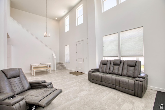 7776 S Iron Core Ln, West Jordan, UT 84081 - living room featuring a towering ceiling, a chandelier, stairway, and baseboards