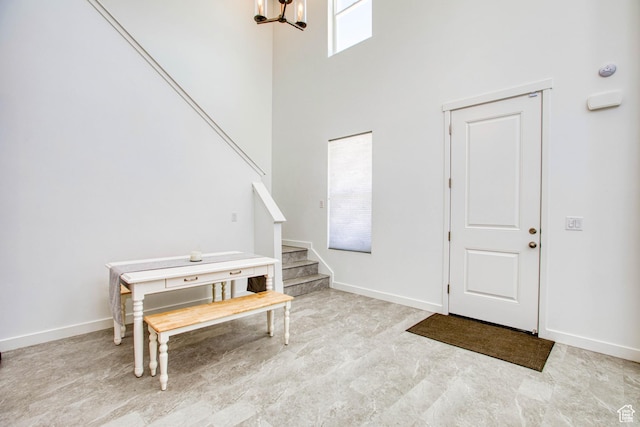 7776 S Iron Core Ln, West Jordan, UT 84081 - foyer with stairway, a chandelier, a towering ceiling, and baseboards