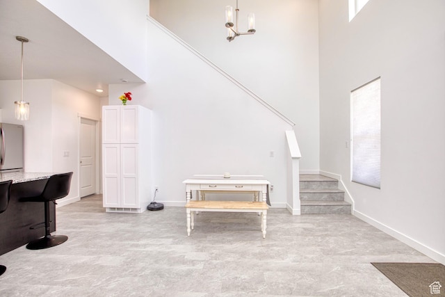 7776 S Iron Core Ln, West Jordan, UT 84081 - living area with a high ceiling, stairs, baseboards, and a chandelier