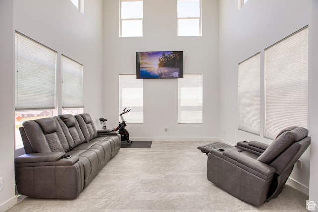 7776 S Iron Core Ln, West Jordan, UT 84081 - living room featuring a high ceiling, baseboards, and light colored carpet
