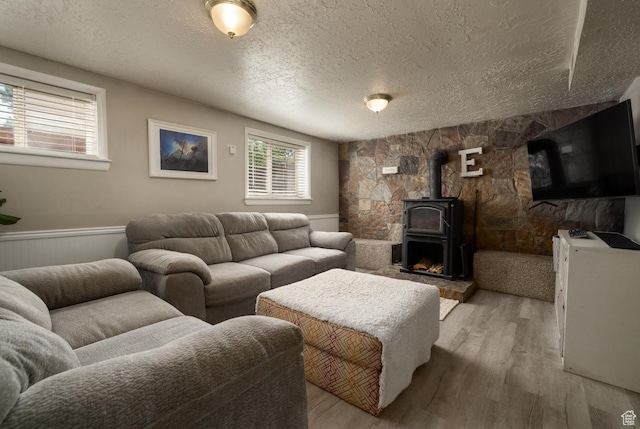 392 N 600 E, Roosevelt, UT 84066 - living room with a wood stove, a textured ceiling, light wood-style floors, and a wainscoted wall
