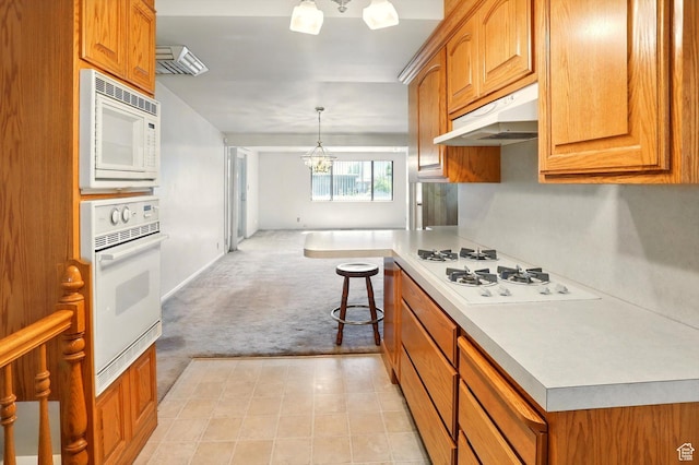 1130 W 1200 N, Provo, UT 84604 - kitchen with white appliances, under cabinet range hood, light carpet, a chandelier, and light countertops