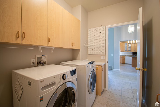 584 S Oak Ln, Tooele, UT 84074 - laundry area with cabinet space, washer and clothes dryer, and light tile patterned floors