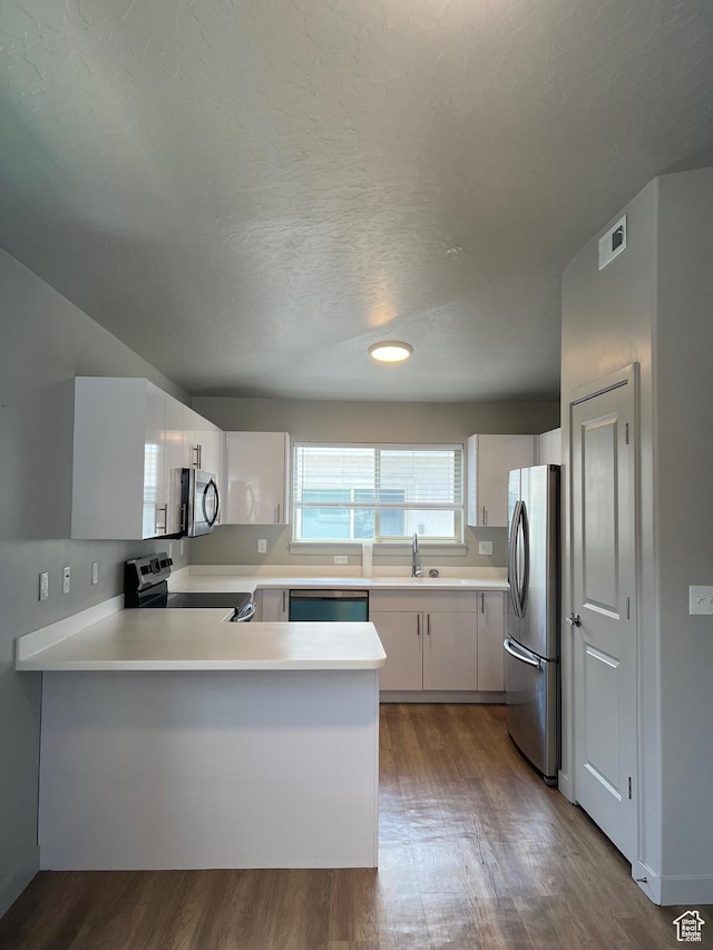 1140 W 950 N Unit C401, Orem, UT 84057 - kitchen featuring appliances with stainless steel finishes, a sink, a peninsula, dark wood finished floors, and light countertops