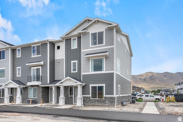 1897 E Thunder Ln Unit 498, Eagle Mountain, UT 84005 - townhome / multi-family property featuring stone siding, a mountain view, central air condition unit, and board and batten siding
