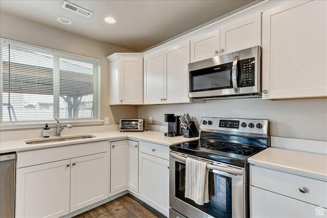 399 N 1325 W, Springville, UT 84663 - kitchen featuring appliances with stainless steel finishes, a sink, wood finished floors, white cabinetry, and light countertops