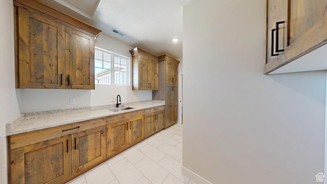 1151 S 4475 W, Cedar City, UT 84720 - kitchen featuring a sink, light tile patterned flooring, recessed lighting, brown cabinets, and light stone countertops