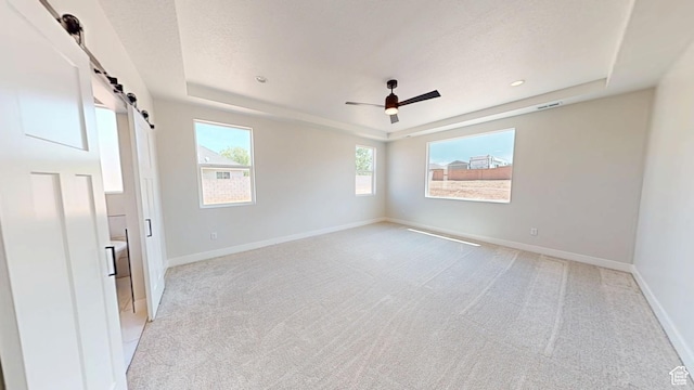 1151 S 4475 W, Cedar City, UT 84720 - unfurnished room featuring a tray ceiling, light carpet, a barn door, baseboards, and recessed lighting