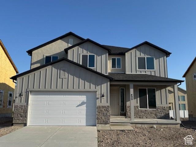 422 W Sapphire Dr Unit 7011, Tooele, UT 84074 - view of front of property with board and batten siding, a porch, stone siding, concrete driveway, and an attached garage