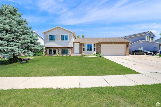 3926 W 5100 S, Roy, UT 84067 - split level home with brick siding, an attached garage, concrete driveway, and a front yard