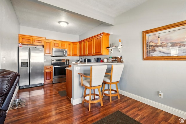 1587 N 565 W Unit 101, Logan, UT 84341 - kitchen featuring appliances with stainless steel finishes, a peninsula, dark wood-type flooring, baseboards, and light countertops