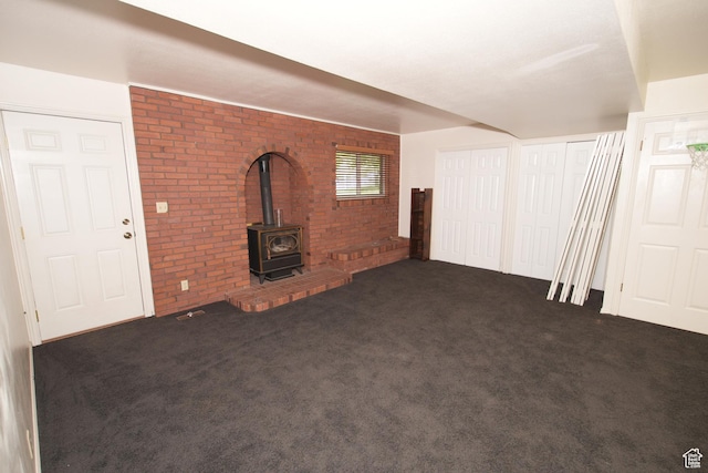 314 W 1700 S, Orem, UT 84058 - unfurnished living room featuring brick wall, carpet flooring, and a wood stove