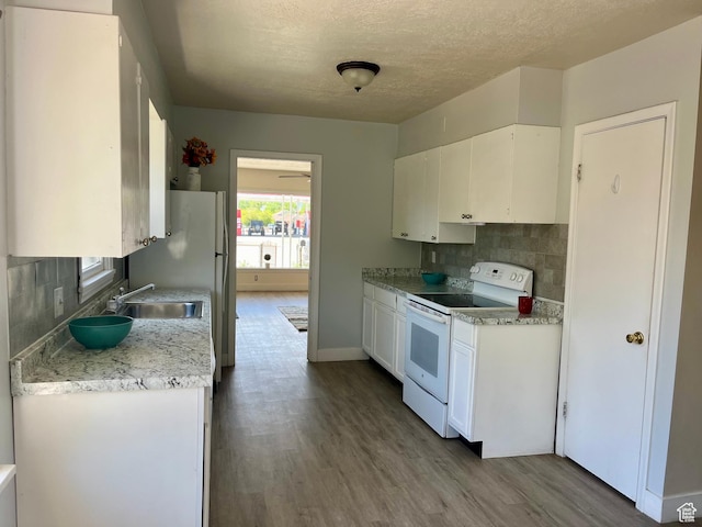 123 S State St, Salina, UT 84654 - kitchen with white electric range oven, white cabinets, decorative backsplash, wood finished floors, and light countertops