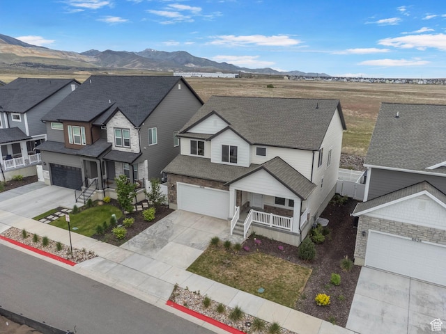 6636 W Ipswitch Way S, Herriman, UT 84096 - view of front of property with a porch, driveway, a mountain view, a shingled roof, and a residential view