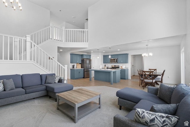 6636 W Ipswitch Way S, Herriman, UT 84096 - living room featuring a chandelier, a high ceiling, stairway, light wood-type flooring, and baseboards