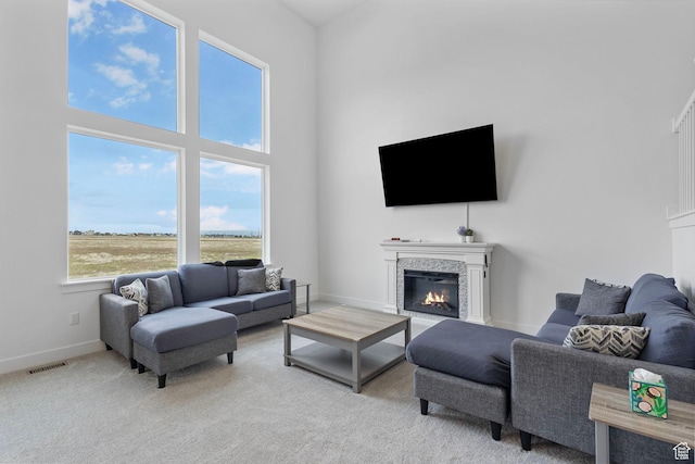 6636 W Ipswitch Way S, Herriman, UT 84096 - living area with a glass covered fireplace, a high ceiling, baseboards, and light colored carpet